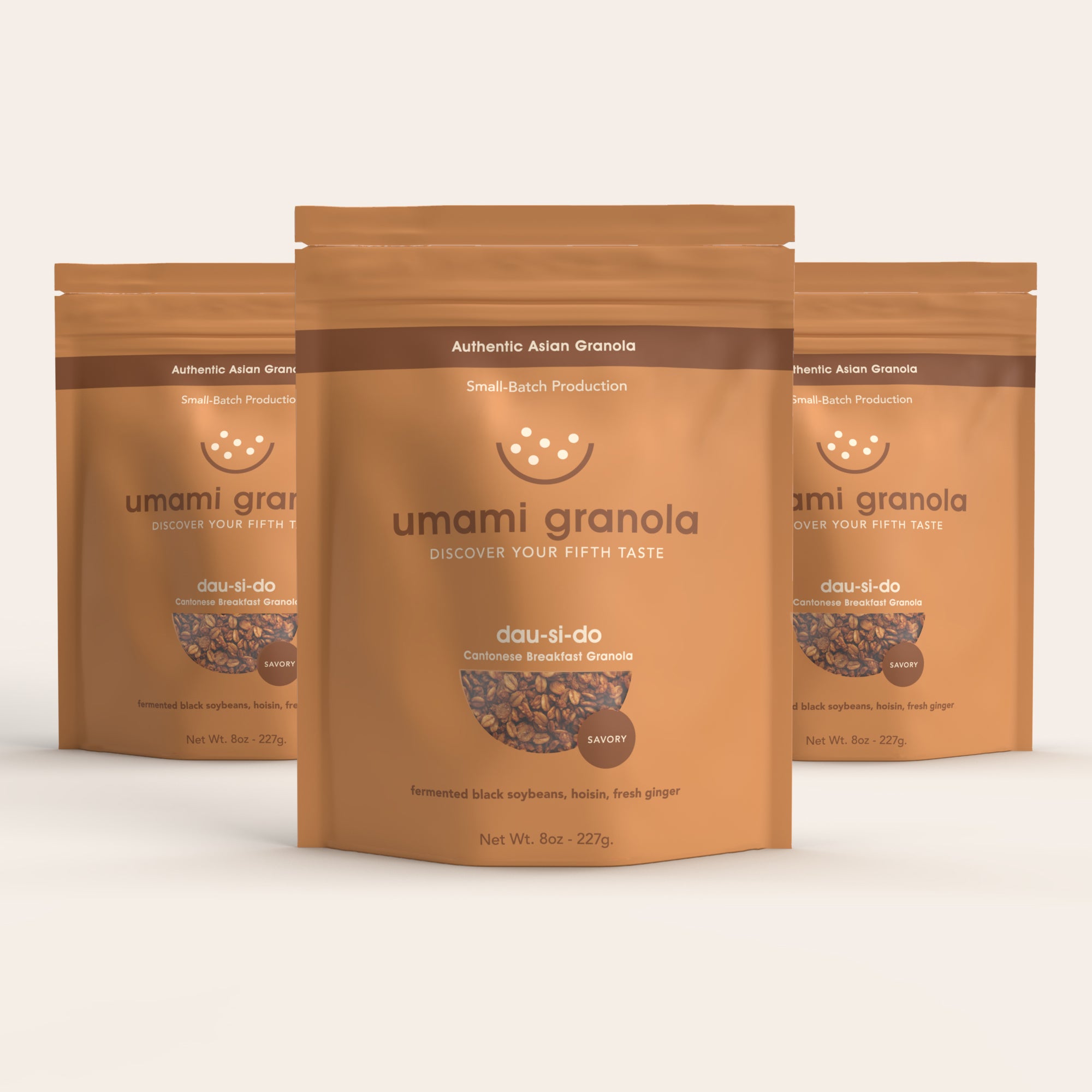 Three packages of umami granola on a light beige background