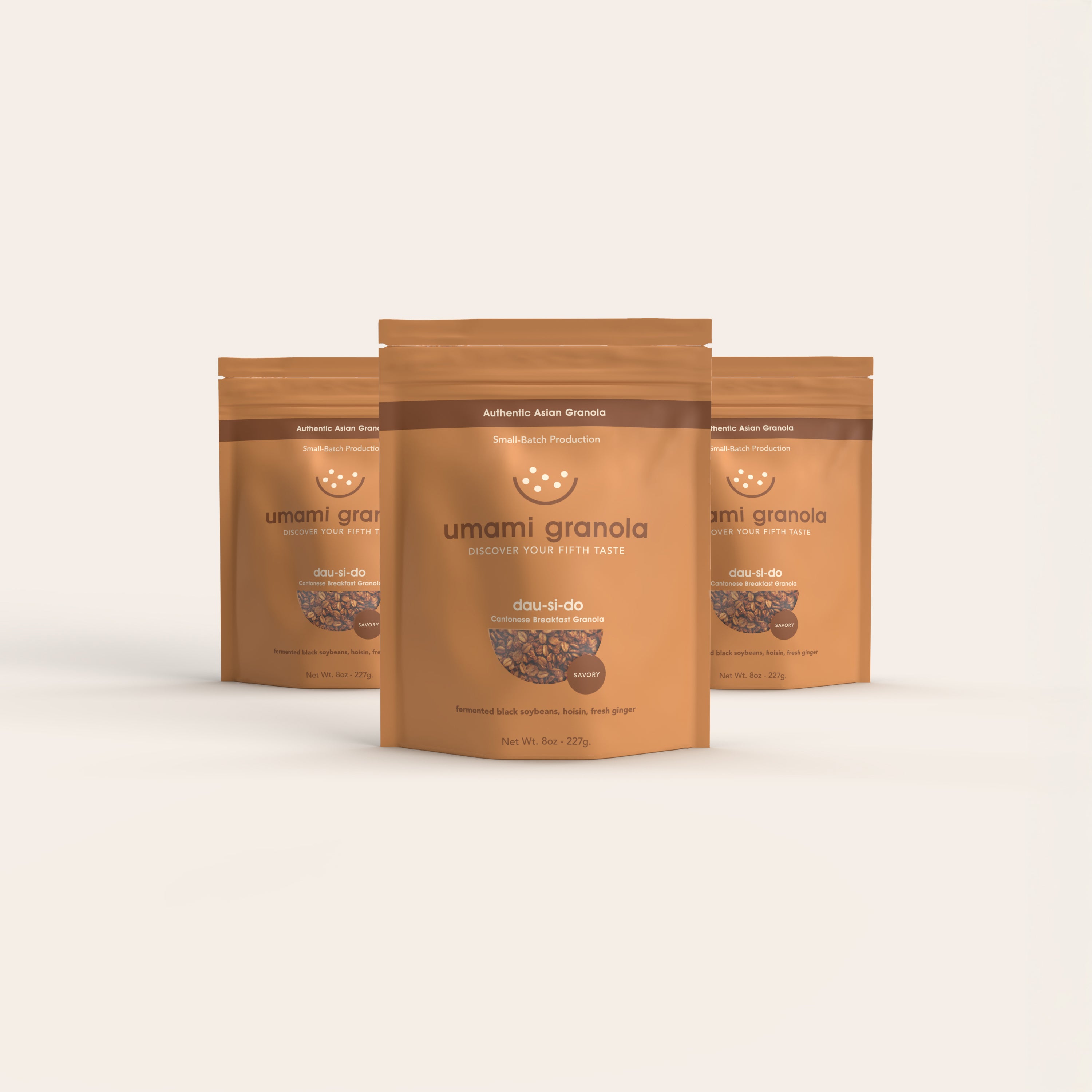 Three packages of umami granola on a light beige background