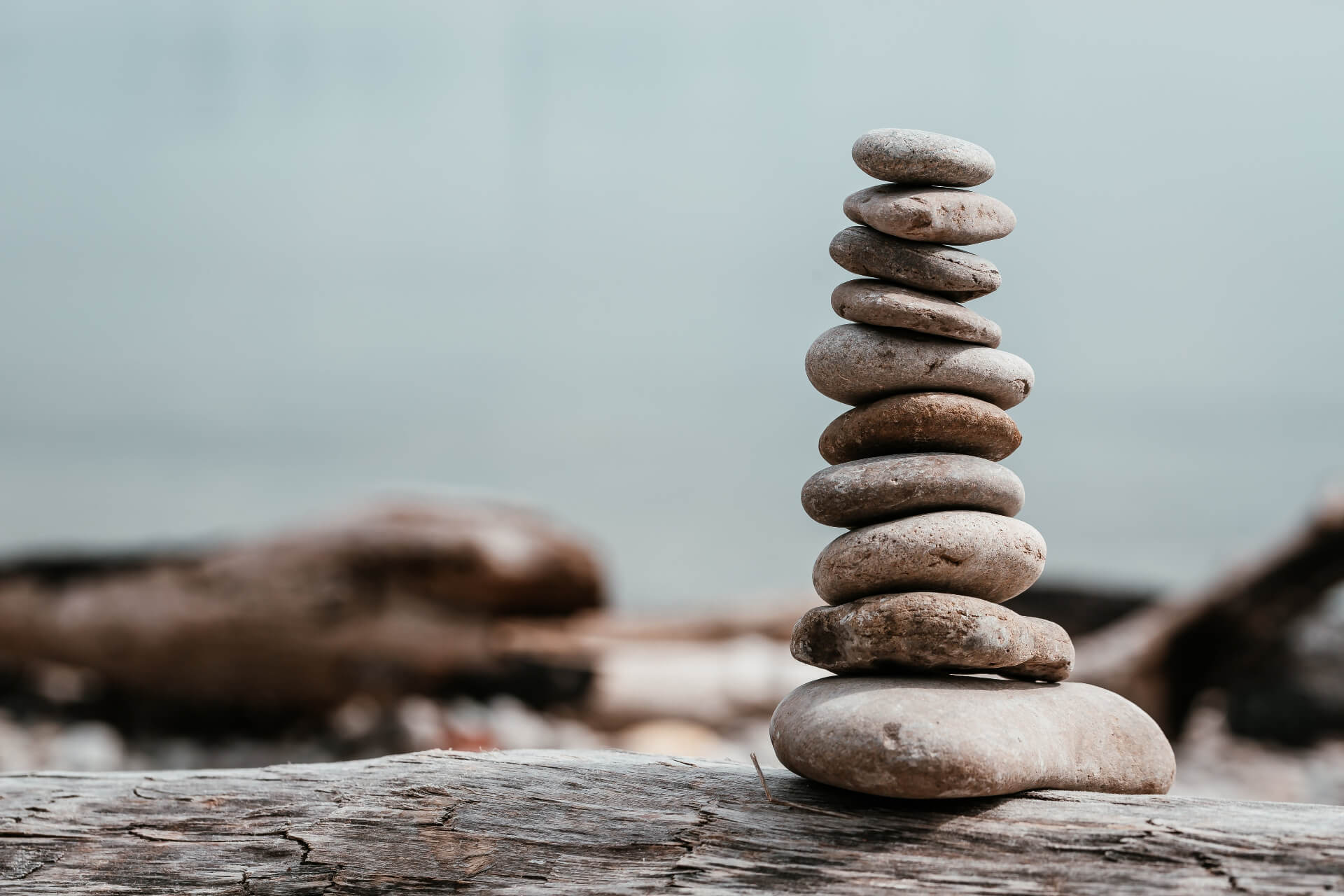 Balanced zen stones stacked by water representing mindfulness and natural balance